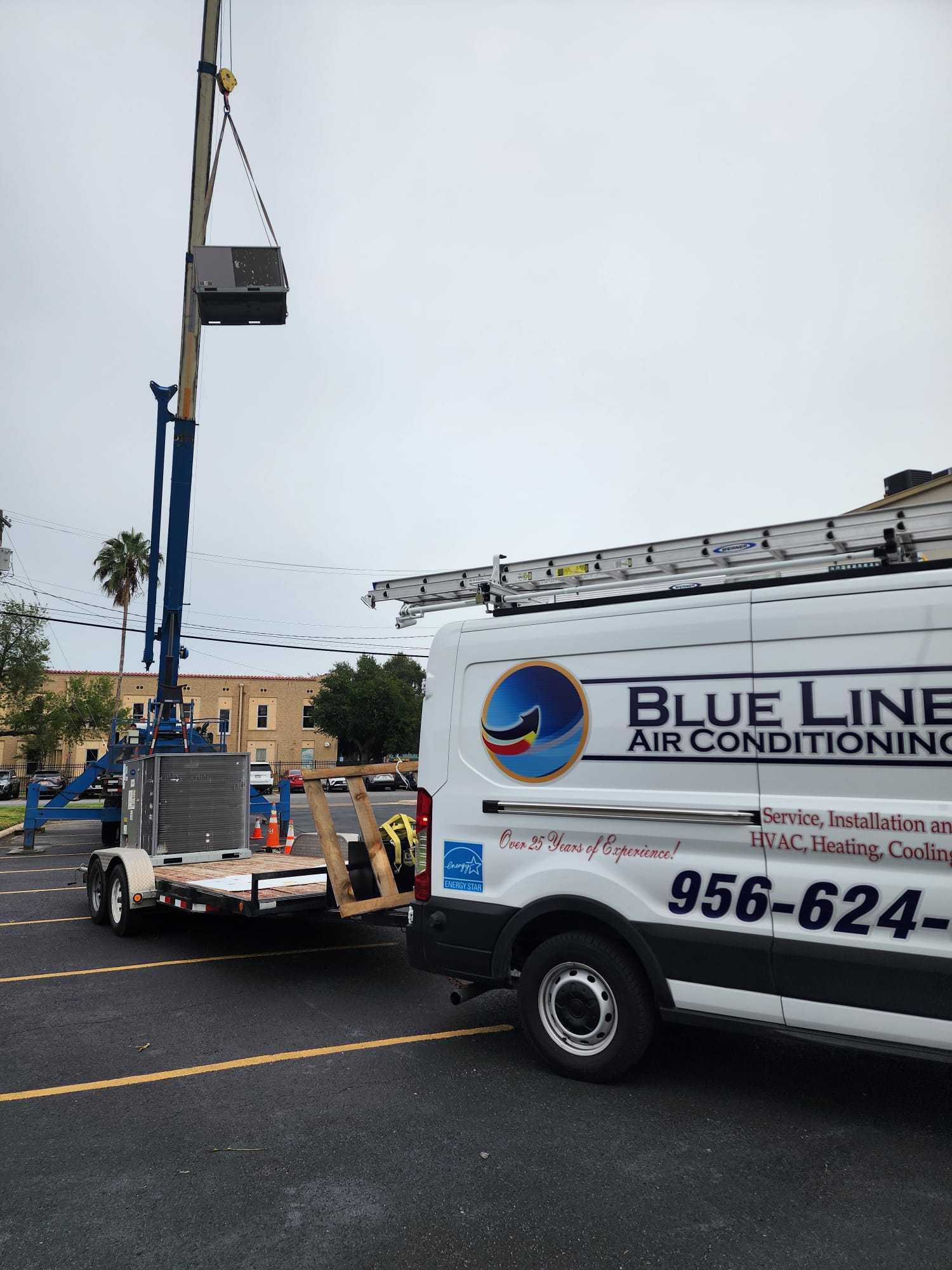 Blue Line crew craning a rooftop AC unit during a commercial install